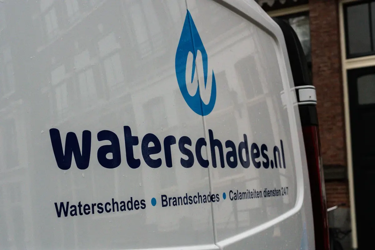 Logo van Waterschades.nl op de zijkant van de servicebus